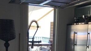 Una cocina moderna con un refrigerador de acero inoxidable, una encimera negra y una ventana con vistas a un balcón.