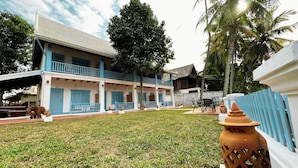 A two-story building with a balcony and a well-maintained lawn. - Sadakham hotel (Luang Prabang)
