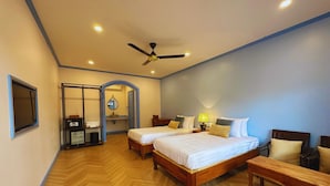 A hotel room with two wooden beds, a ceiling fan, a bathroom with a sink and mirror, and a wooden bench. - Sadakham hotel (Luang Prabang)