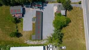 Vue aérienne d’une propriété comprenant des places de stationnement numérotées, un chalet et une maison.