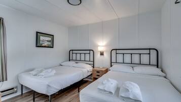 Two single beds with black headboards and wooden nightstands, a framed picture on the wall.