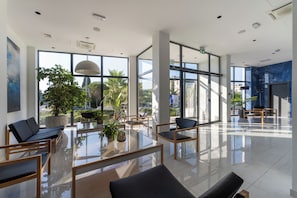 A spacious lobby with modern furnishings, large windows, and indoor plants. - Miramare Hotel Zadar (Zadar)