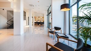 A modern interior with a staircase, seating area, and a bookshelf. - Miramare Hotel Zadar (Zadar)