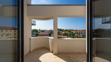 Un balcón con vistas despejadas a un barrio residencial, con casas y árboles.