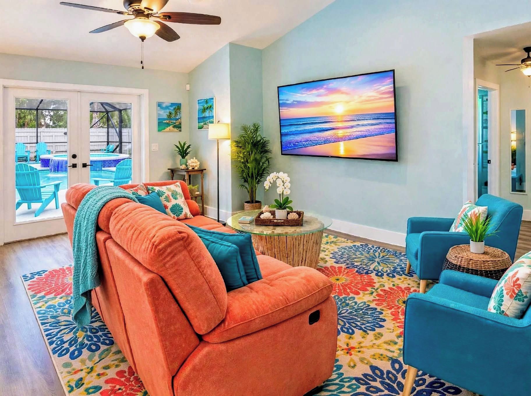 Sala de estar con sofá, sillas, televisor y vista a la piscina.