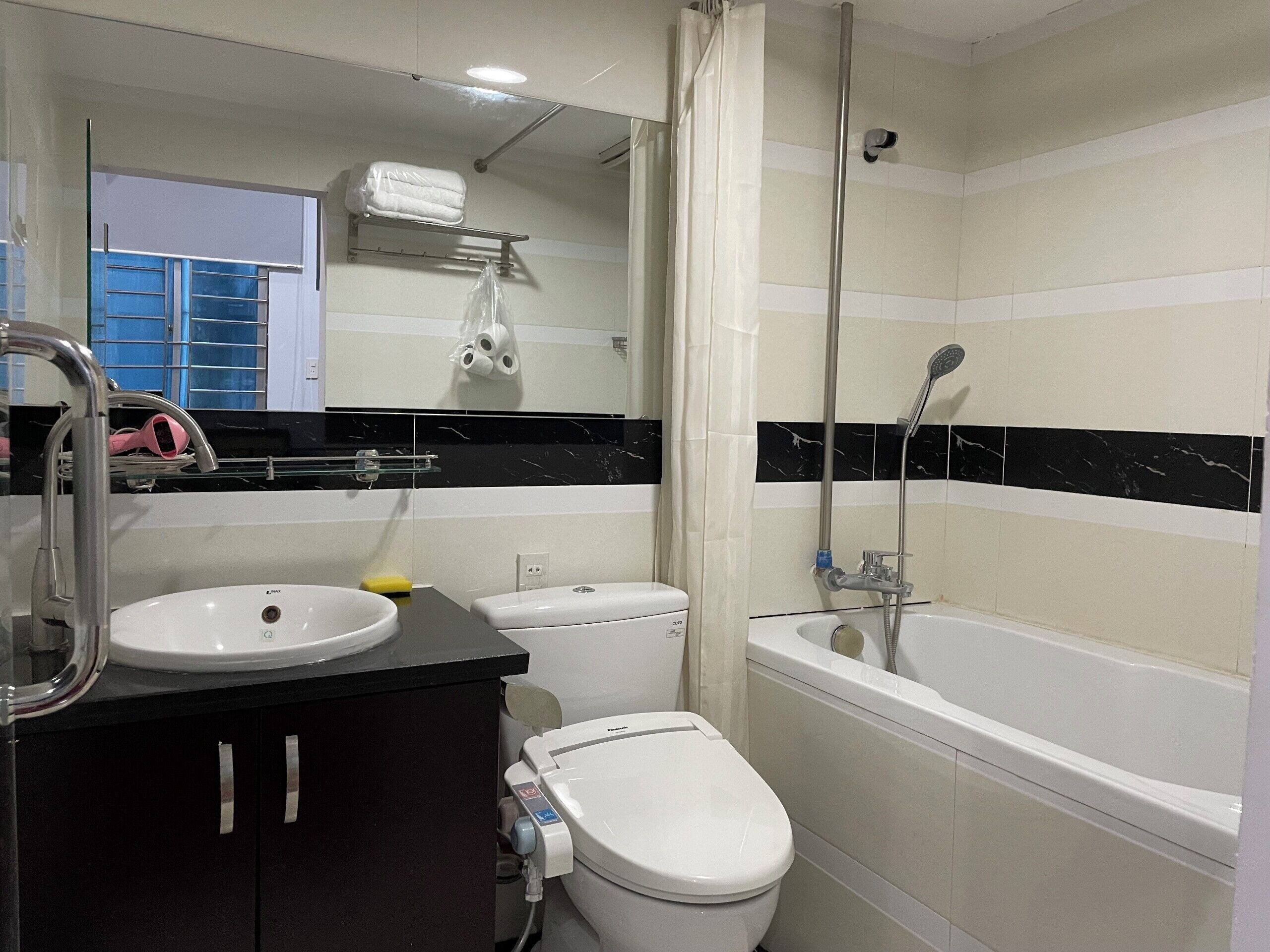 Un baño con lavamanos, inodoro y bañera.