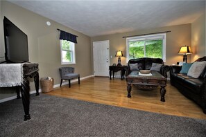 A living room with a television, a fireplace, a sofa, and a coffee table.