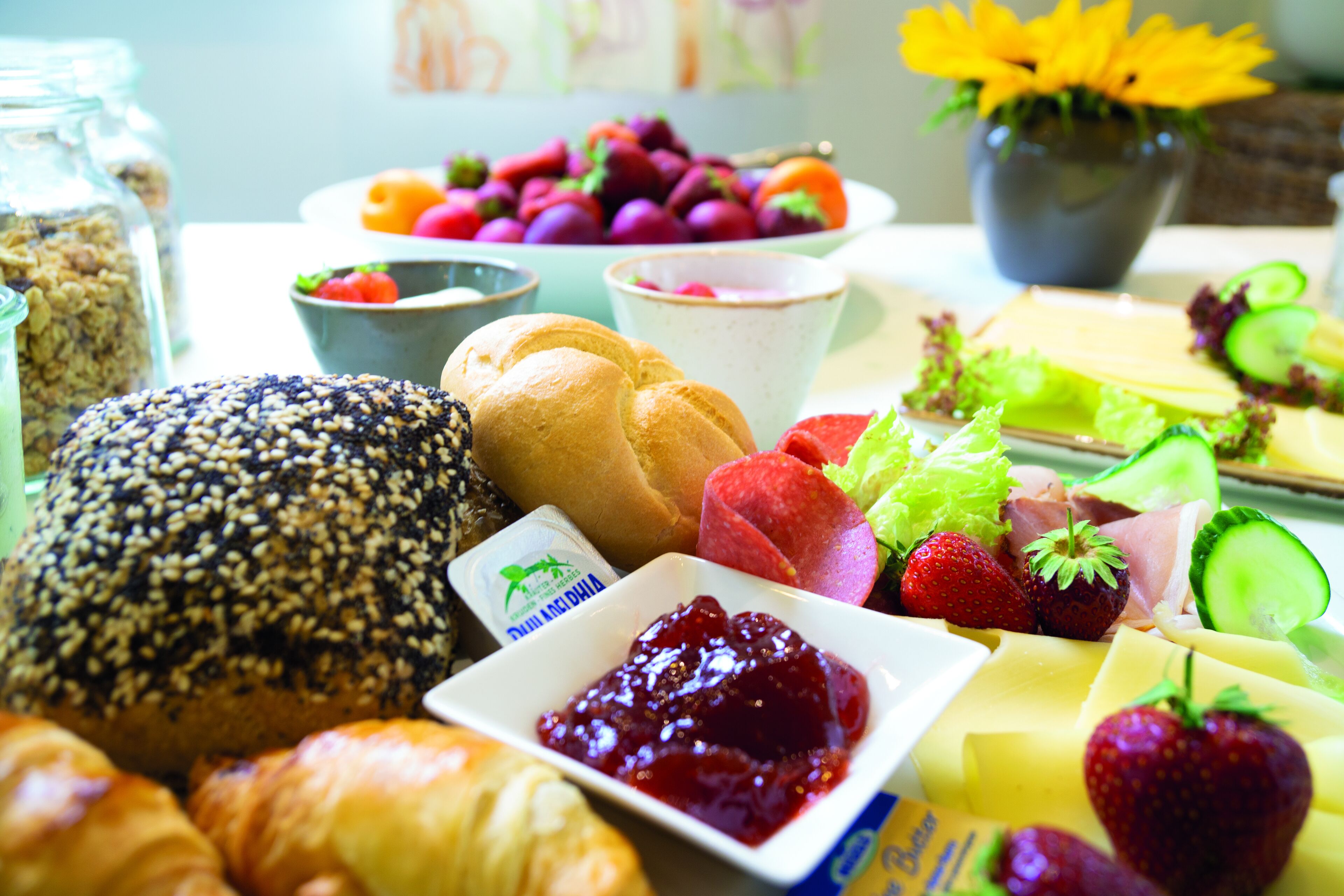 En frukostbuffé med ett varierat utbud av mat, inklusive bröd, frukt och ost.