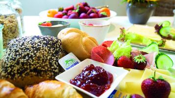 En frukostbuffé med ett varierat utbud av mat, inklusive bröd, frukt och ost.