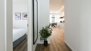 Een modern appartement met een gang die leidt naar een eetgedeelte en keuken.