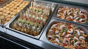 Un bufet amb diversos plats de marisc, incloent rotlles de gambes i cranc, i altres opcions de marisc.