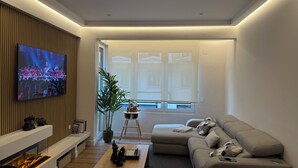 A modern living room with a flat-screen TV, a fireplace, a sofa, and a coffee table. - APARTAMENTO  NUEVO, LUJOSO, CENTRO DE BILBAO. (Bilbo)