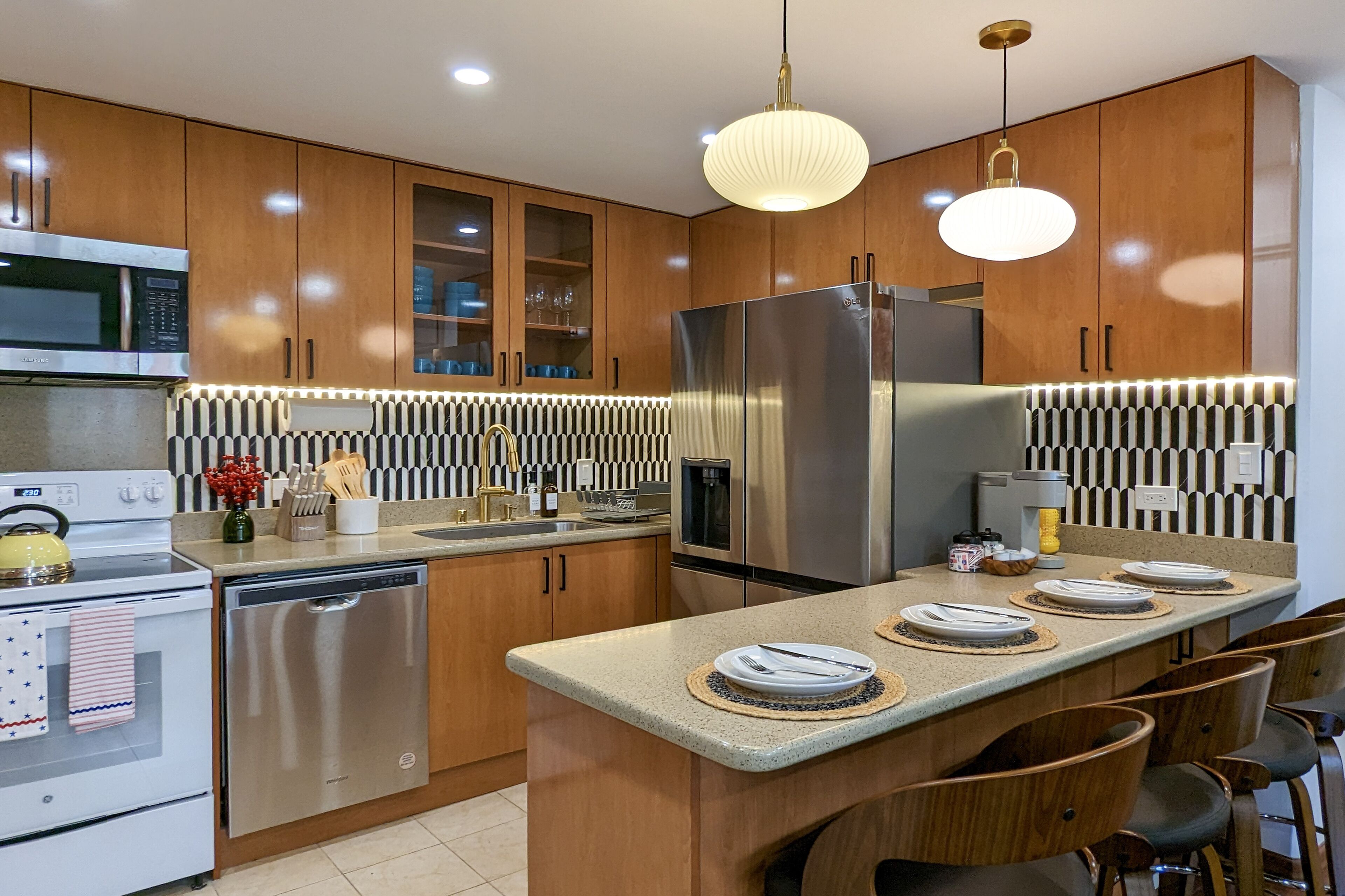 A modern kitchen with wooden cabinets, stainless steel appliances, and a central island with seating.