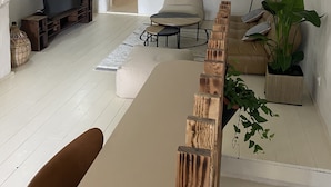 A spacious living area with a high arched ceiling, a wooden coffee table, a sofa, and a television.