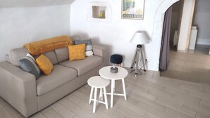 A living room with a sofa, two small tables, a lamp, and a framed picture on the wall. - Les Insolites de Champeix 3 (Champeix)