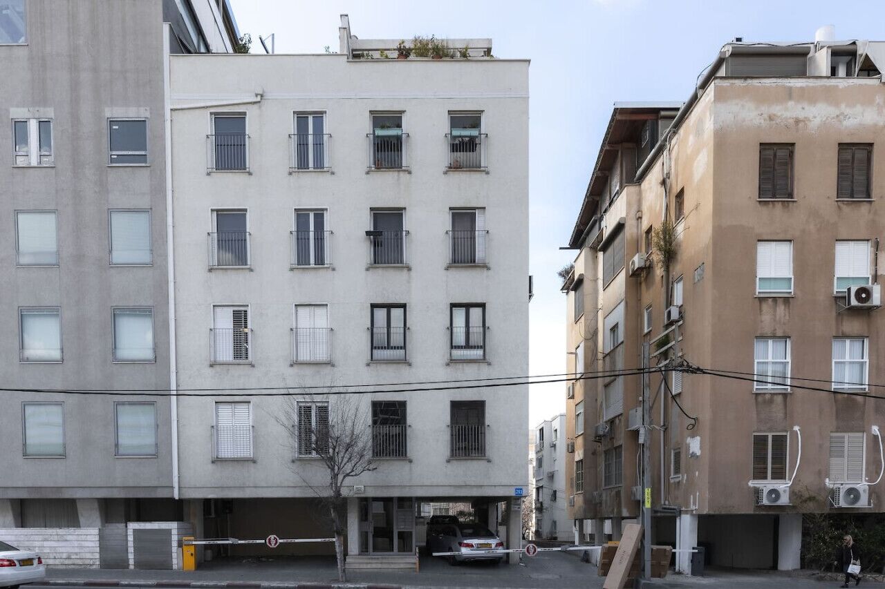 Ein mehrgeschossiges Gebäude mit flacher Fassade, zahlreichen Fenstern und Klimaanlagen.