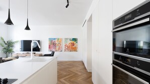 A modern kitchen with a white island, black pendant lights, and a large oven. - Spacious & Modern 3BD Apartment 2-min From Beach (Tel Aviv)