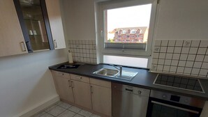 A compact kitchen with a window, tiled backsplash, and modern appliances. - Ferienwohnung, Zimmer, Lindhorst, Steinhuder Meer (Lindhorst)