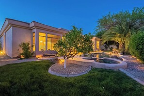 A modern house with a swimming pool, a well-maintained lawn, and a patio area.