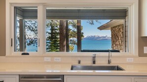 A kitchen with a large window overlooking a lake and mountains. - Sapphire Lakefront in Dollar Point, 3BR + 1BR Guest Unit, with Buoy! (Tahoe City)
