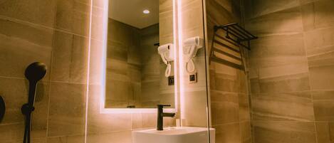 A modern bathroom with a glass-enclosed shower, a marble sink, and a toilet.