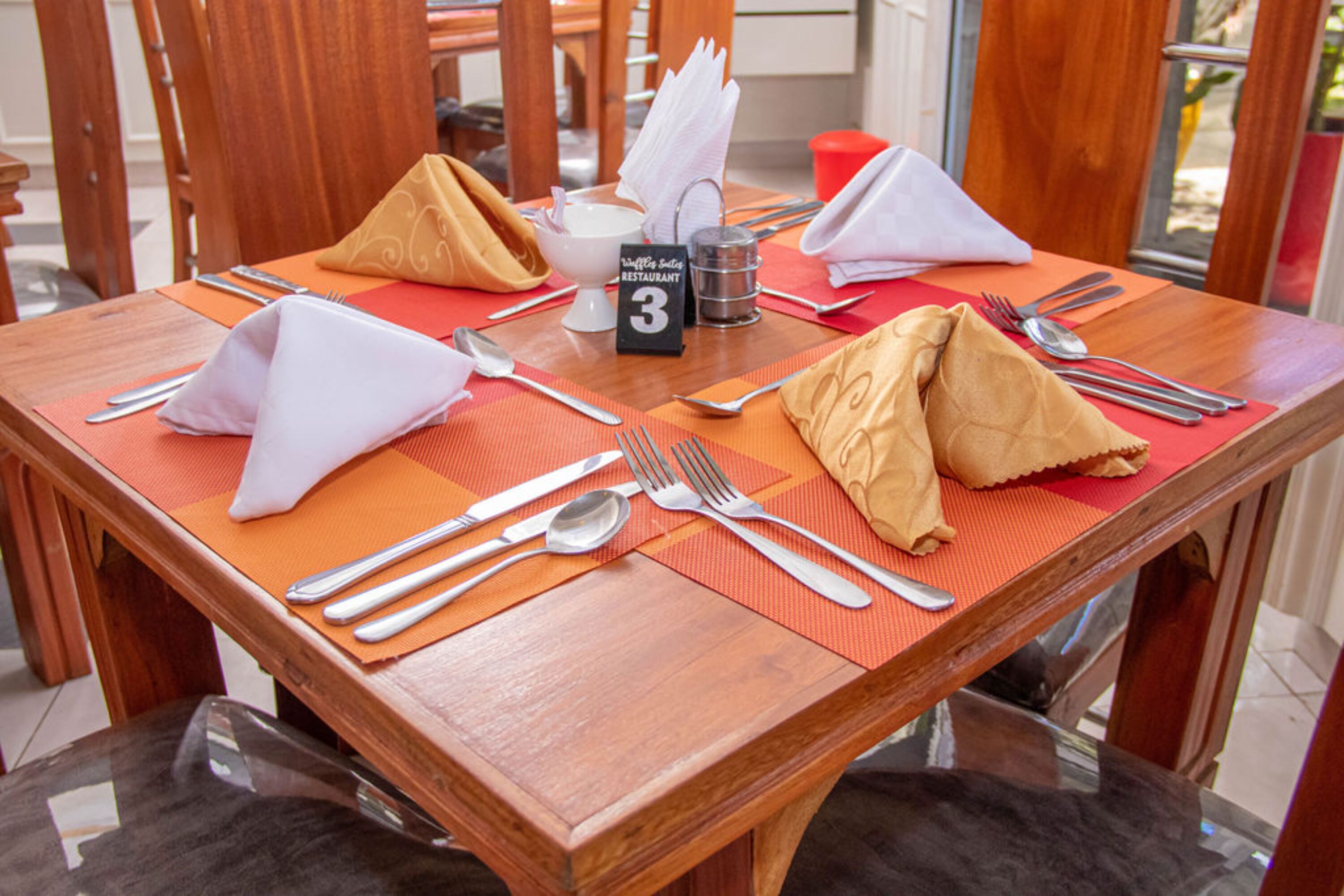 A dining table set with a placemat, numbered 3, and various cutlery.