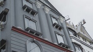 Un immeuble à plusieurs étages, doté d’éléments architecturaux classiques, notamment des colonnes et des moulures décoratives.