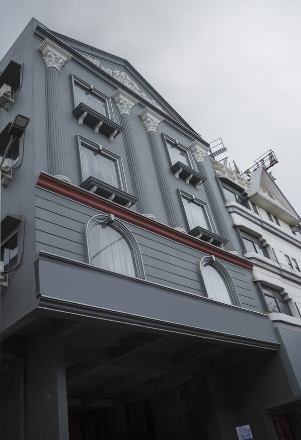 A multi-story building with classical architectural elements, including columns and decorative moldings. - Signature Inn (Nagpur)