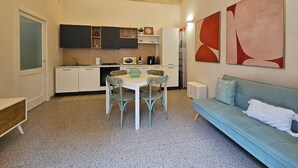 En kompakt bolig med tekøkken, spiseplads og sofa.