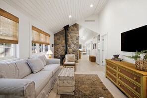 A spacious living room with a sofa, armchair, and a television. - Pro Designer Cottage, 4/10 Mile to New Circle Beach (Lakeside)