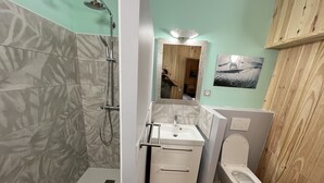 Un baño con ducha, lavabo e inodoro.