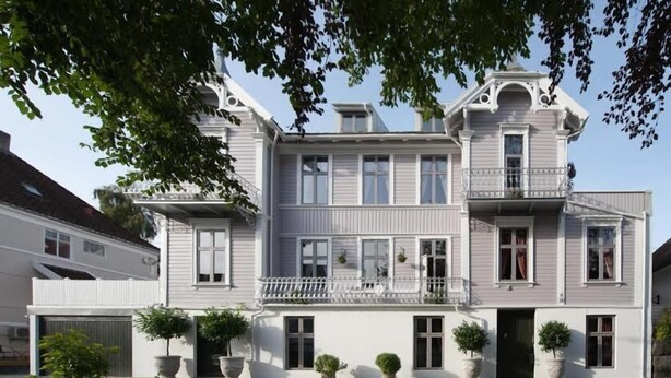 A two-story building with a balcony, large windows, and potted plants. - Villa Eckhoff (Stavanger)