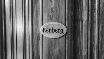 A metal plaque with the name "Renberg" on a wooden surface.