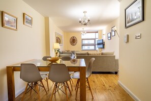 Cozy living space with a dining area, sofa, and flat-screen TV.