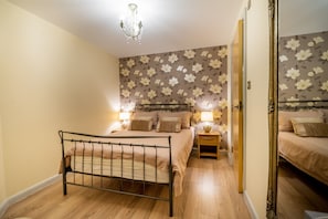 Classic bedroom with a bed, bedside tables, and a mirror.