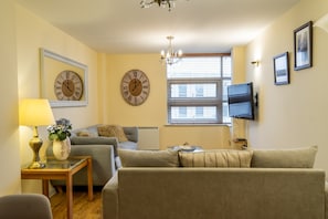 Relax in this stylish living room with a comfortable sofa, side table, and flat-screen TV.