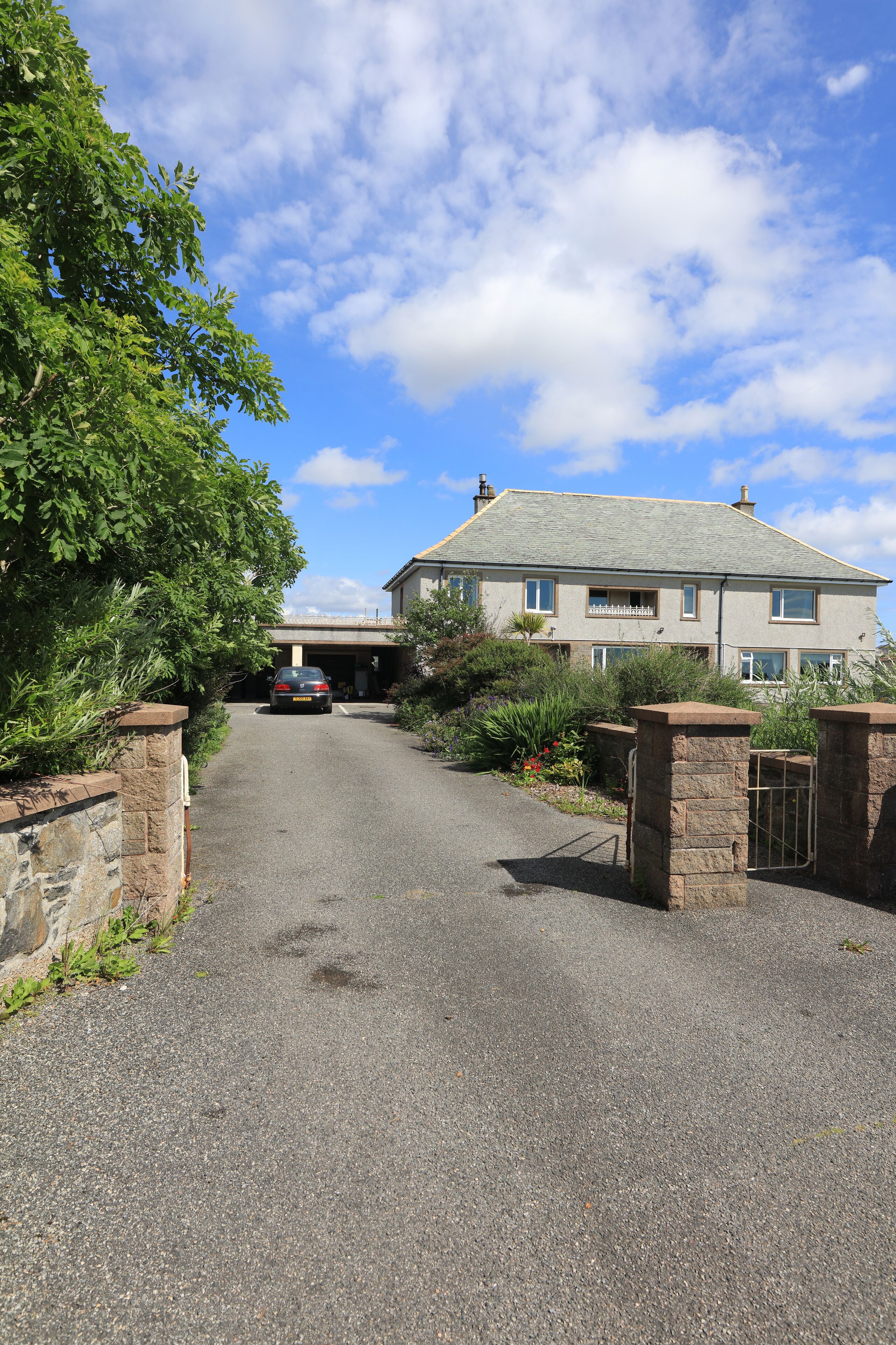 A driveway leading to a two-story house with a garage.