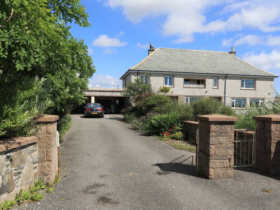 A driveway leading to a two-story house with a garage.