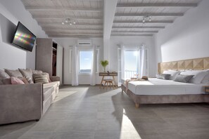 Un dormitorio moderno con una cama grande, un sofá, un escritorio y un televisor.