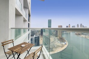 Enjoy a city view from this balcony with a table and bench, perfect for relaxation or dining.