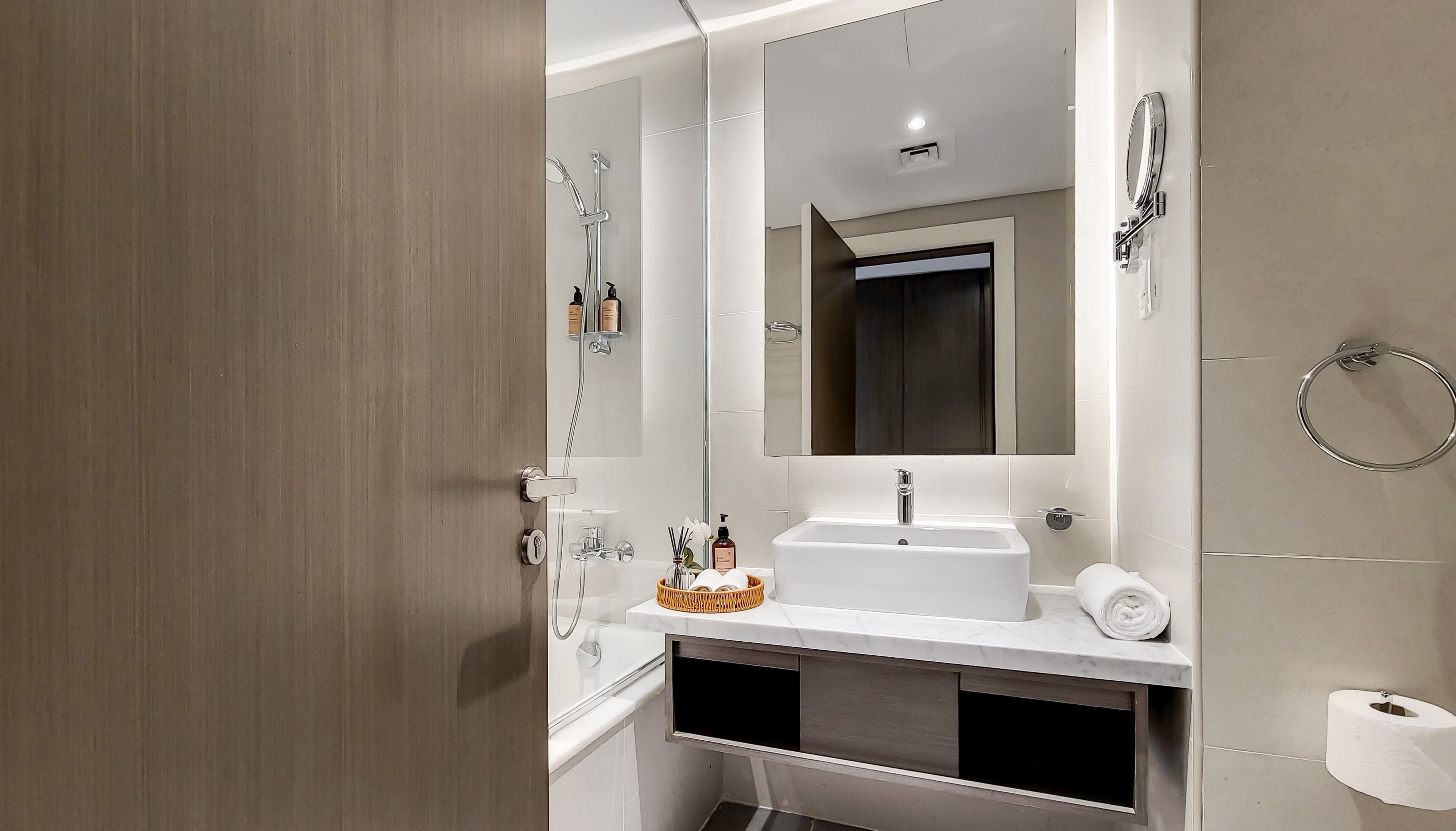 Ein modernes Badezimmer mit großem Spiegel, Waschbecken, Dusche und Toilette.
