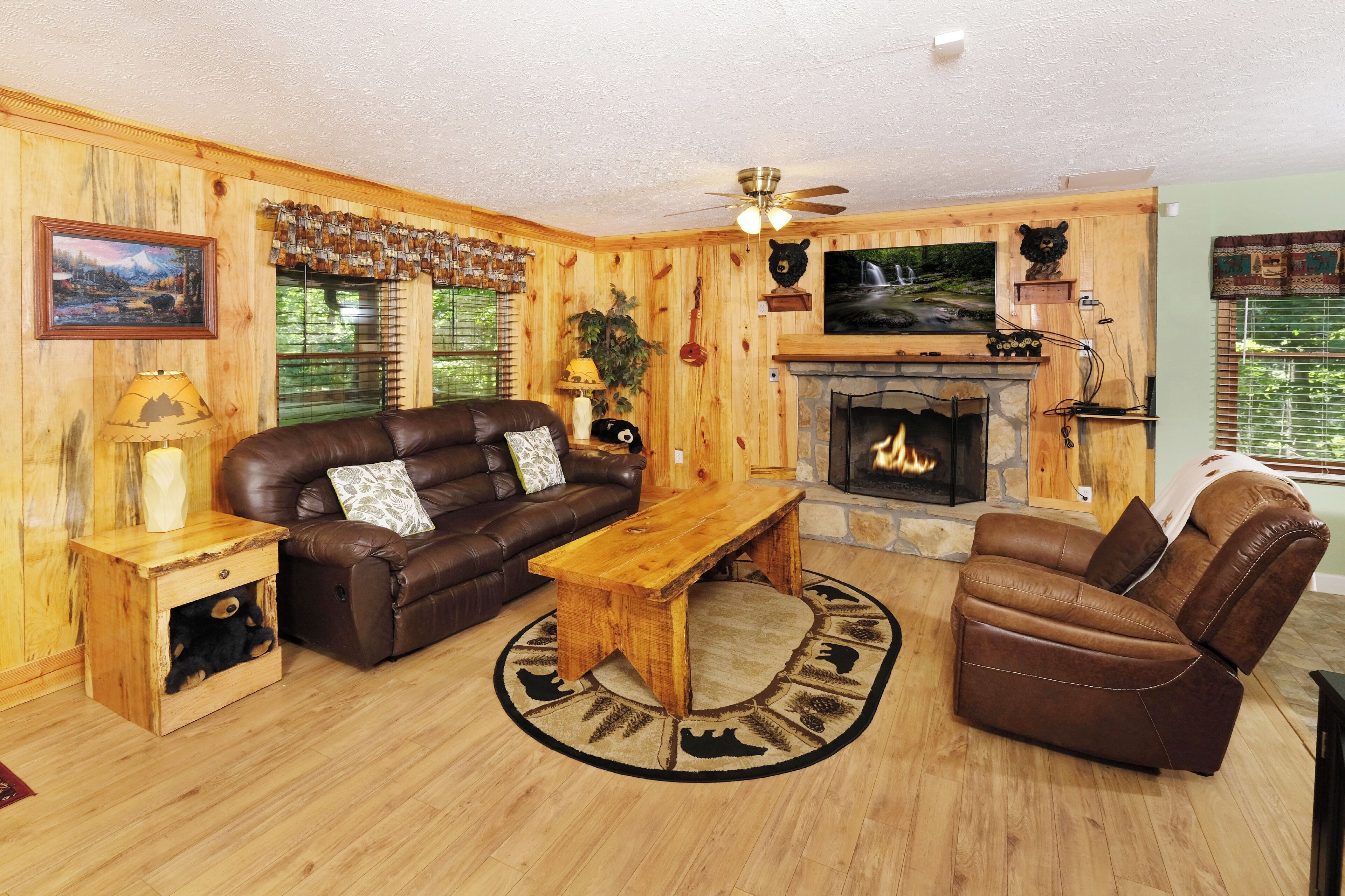 A cozy living room with a fireplace, leather sofa, and a wooden coffee table.