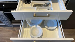 Un cassetto della cucina con utensili e piatti.