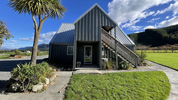 A modern house with a metal roof, a wooden staircase, and a well-maintained lawn. - Chalet 3 (5 Bed) Pudding Hill (Methven)