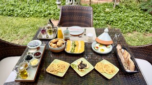 A breakfast table set outdoors with various dishes, including pastries, fruits, and beverages. - Sillage Palace Sky & Spa  (Marrakech)