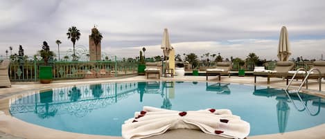 Una piscina cubierta, una piscina al aire libre, sombrillas, tumbonas