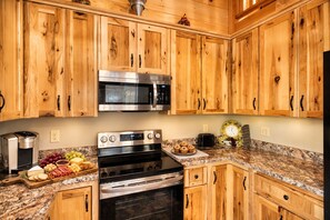 A kitchen with wooden cabinets, a stainless steel microwave, an LG oven, and a granite countertop.