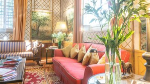 A cozy living room with a red sofa, a striped armchair, and a glass coffee table. There is a lamp, a vase with flowers, and a painting on the wall. - Villa in Florence with 5 bedrooms sleeps 10 (Florence)