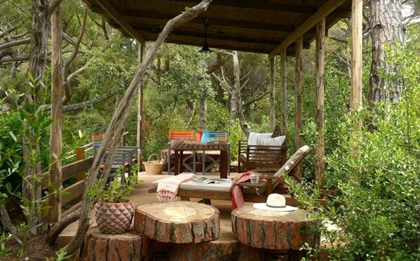 Guests can sit and enjoy meals in this outdoor seating area surrounded by lush greenery.