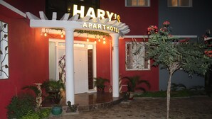 A hotel entrance with a white pergola, a sign reading "HARY'S APARTHOTEL," and a potted plant in the foreground. - Hary's aparthotel (Toliara)